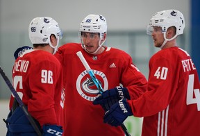 Vancouver Canucks’ Ilya Mikheyev, centre, of Russia, talks to Andrei Kuzmenko, left, of Russia, and Elias Pettersson, of Sweden, during training camp in Whistler.