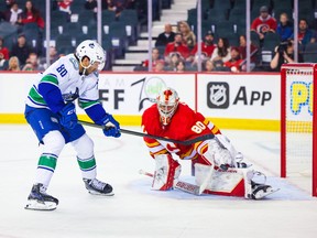 Vancouver Canucks left wing Arshdeep Bains (80) shoot the puck against Calgary Flames goaltender Dan Vladar (80) during the second period at Scotiabank Saddledome.