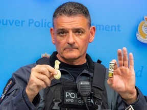 John Roberts with VPD's tactical training centre holds a bean bag round (left) and the shotgun round from which it is fired (right).