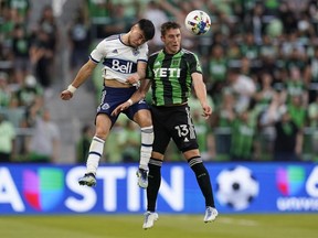 Vancouver Whitecaps FC midfielder Ryan Raposo, left, and Austin FC midfielder Ethan Finlay (13) leap for the ball during the first half of an MLS soccer match on April 23, 2022, in Austin, Texas.