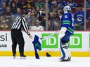 Canucks goalie Thatcher Demko picks up a jersey that was thrown onto the ice by a fan in the third period during their NHL game against the Buffalo Sabres at Rogers Arena Oct. 22, 2022. Buffalo won 5-1.