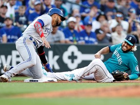 Blue Jays baserunner Lourdes Gurriel Jr., left, goes in hard at third base as the Mariners' Eugenio Suarez reacts during a game this summer between the 1977 expansion cousin franchises at T-Mobile Park in Seattle. The Mariners won five of seven games between the clubs this season.