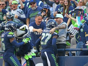 Tariq Woolen #27 of the Seattle Seahawks celebrates an interception against the Arizona Cardinals with fans during the fourth quarter at Lumen Field on October 16, 2022 in Seattle, Washington.