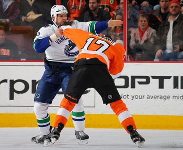 Kevin Bieksa #3 of the Vancouver Canucks and Wayne Simmonds #17 of the Philadelphia Flyers fight in the first period on January 15, 2015 at the Wells Fargo Center in Philadelphia, Pennsylvania.