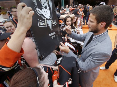 Kevin Bieksa #2 of the Anaheim Ducks signs autographs for fans before the game against the Vancouver Canucks on October 12, 2015 at Honda Center in Anaheim, California.