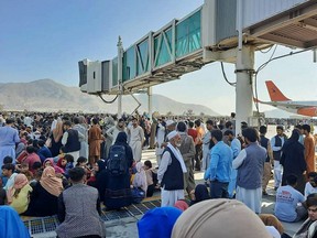 Afghans crowd at the tarmac of the Kabul airport on Aug. 16, 2021, to flee the country as the Taliban were in control of Afghanistan after President Ashraf Ghani fled the country and conceded the insurgents had won the 20-year war.