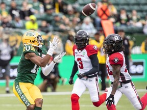 Ottawa Redblacks Patrick Levels (3) and Alonzo Addae (20) try to stop Edmonton Elks Dillon Mitchell (17) as he makes a catch in Edmonton on Aug. 27, 2022.