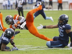 B.C. Lions running back James Butler (centre) is brought down by Toronto Argonauts' Robert Priester (left) and Brandon Barlow during first half of CFL football action in Toronto on Saturday Oct. 8, 2022