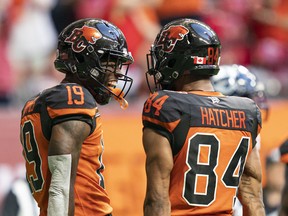 BC Lions' Dominique Rhymes (left) celebrates with teammate Keon Hatcher after scoring one of his two touchdowns against the Toronto Argonauts at B.C. Place in June.