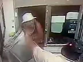 A man, left, throws things at a drive-thru during a dispute over his order.