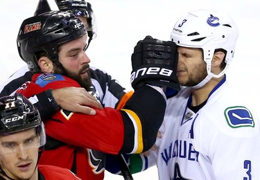 Calgary Flames Brandon Bollig battles  Vancouver Canucks Kevin Bieksa in second period NHL Play-Off action at the Scotiabank Saddledome in Calgary, Alta. on Sunday April 19, 2015. Darren Makowichuk/Calgary Sun