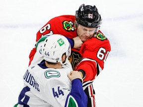 Vancouver Canucks defenceman Kyle Burroughs (44) fights with Chicago Blackhawks defenceman Riley Stillman (61) during the first period at United Center in October 2021.