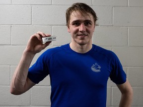 Abbotsford Canucks forward Linus Karlsson poses with the puck after scoring his first AHL goal on Saturday, Oct. 15, 2022.