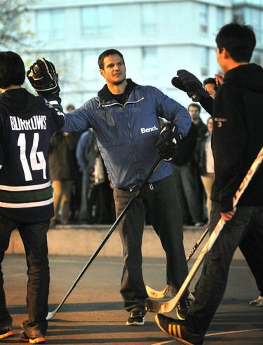 Vancouver Canucks locked-out players Kevin Bieksa celebrates a goal for his team as he and teammate Ryan Kesler joined fans of all ages for a street hockey game at the basketball courts under the Cambie Street Bridge as the NHL disruption continues in Vancouver, December 05, 2012.