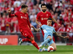 Soccer Football - FA Cup Semi Final - Manchester City v Liverpool - Wembley Stadium, London, Britain - April 16, 2022 Manchester City's Joao Cancelo in action with Liverpool's Roberto Firmino and Mohamed Salah.