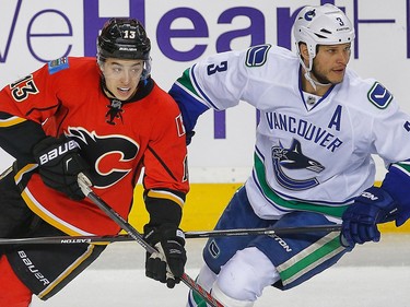 Calgary Flames Johnny Gaudreau ballets against Kevin Bieksa of the Vancouver Canucks during the 2015 NHL Stanley Cup Playoffs in Calgary, Alta. on Tuesday April 21, 2015. Al Charest/Calgary Sun
