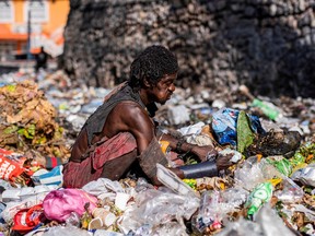 A man looks for food through piles of trash on the side of a street in Port-au-Prince, Haiti October 16, 2022. REUTERS/Ricardo Arduengo