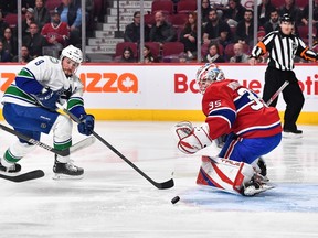 JT Miller #9 of the Vancouver Canucks skates the puck near Montreal Canadiens goalie Sam Montembaugh #35 during the first period at the Center Bell in Montreal, Quebec, Canada, November 9, 2022.