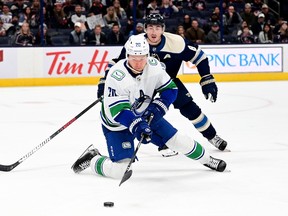 Vancouver Canucks' Curtis Lazar controls the puck against Columbus Blue Jackets' Zach Werenski in the third period at Nationwide Arena on October 18, 2022.