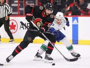 Derrick Blassard #61 of the Ottawa Senators protects the puck from Vasily Podkordin #92 of the Vancouver Canucks during the first period of a game at the Canadian Tire Center in Ottawa, Ontario, Canada, November 8, 2022.
