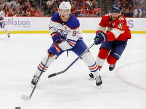 Nov 12, 2022; Sunrise, Florida, USA; Edmonton Oilers center Connor McDavid (97) skates with the puck ahead of Florida Panthers center Aleksander Barkov (16) during the first period at FLA Live Arena.