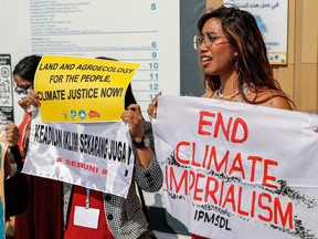 A climate protester holds a banner during a climate demonstration at the Sharm el-Sheikh International Convention Centre, during the COP27 climate conference in Egypt on November 14, 2022.