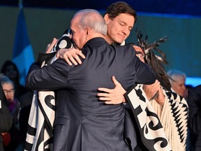 Former premier John Horgan greets David Eby prior to Eby being sworn in as B.C.'s premier at the Musqueam Community Centre