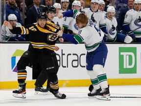 Boston Bruins' A.J. Greer (10) fights with Vancouver Canucks' Vasily Podkolzin during the first period on Sunday, Nov. 13, 2022, in Boston.