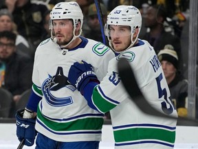 Vancouver Canucks' Bo Horvat, right, reacts after J.T. Miller (9) scored against the Vegas Golden Knights during the first period of an NHL hockey game Saturday, Nov. 26, 2022, in Las Vegas.