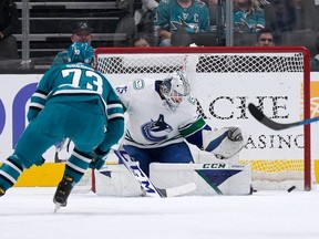Thatcher Demko blocks a shot by San Jose Sharks centre Noah Gregor (73) during the first period on Sunday in San Jose, Calif.