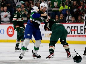 Canucks defenceman Riley Stillman (left) engages in a spirited bout with Minnesota Wild winger Brandon Duhaime during an Oct. 20, 2022 NHL game in St. Paul, Minn.