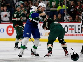 Canucks defenseman Riley Stillman (left) engages in a spirited battle with Minnesota Wild winger Brandon Duhaime during a game October 20 in St. Paul, Minn.