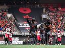BC Lions' Keone Hatcher (4) runs the ball into the end zone for a touchdown after Dominic Rimes (19) and Jevon Cotoy (86) cheer in the second half of the CFL Western Semifinal football game. Calgary Stampeders at BC Place on Sunday.