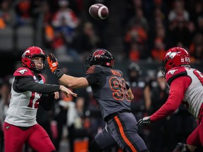 Calgary Stampeders quarterback Jake Maier, left, passes while under pressure from B.C. Lions’ Mathieu Betts (90) during the first half on Sunday.