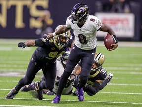 Baltimore Ravens quarterback Lamar Jackson (8) scrambles away from New Orleans Saints defensive end Cameron Jordan (94) and safety Tyrann Mathieu (32) during the second half at Caesars Superdome.