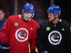 Former Vancouver Canucks defenceman Kevin Bieksa, right, who signed a one-day contract with the NHL hockey team to officially retire, talks with captain Bo Horvat as he skates with the team at the start of practice, in Vancouver, on Thursday, November 3, 2022. Bieksa will be honoured by the team with a retirement celebration prior to their game against the Anaheim Ducks on Thursday night.