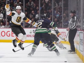Vegas Golden Knights' Paul Cotter (left) jumps to avoid a hit by Vancouver Canucks' Luke Shen (2) in the second period.