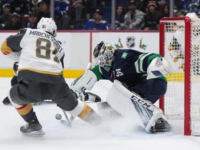 Vancouver Canucks goalie Thatcher Demko, right, stops Vegas Golden Knights’ Jonathan Marchessault during the first period on Monday night.