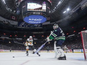 Vancouver Canucks goalie Thatcher Demko, right, plays the puck away from Vegas Golden Knights' Reilly Smith during the third period of an NHL hockey game in Vancouver, on Monday, November 21, 2022. Canucks head coach Bruce Boudreau wasn't giving anything away on which of his goalies would start Saturday and who would start Sunday in San Jose. But he did have Spencer Martin working in the Canucks' goal at practice on Friday.