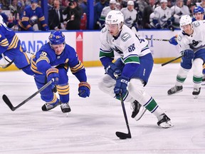 Vancouver Canucks centre Nils Aman (88) moves the puck past Buffalo Sabres defenceman Rasmus Dahlin (26) in the first period at KeyBank Center.