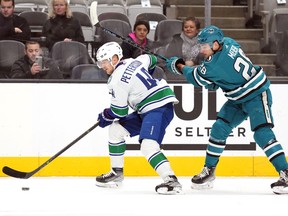 Elias Pettersson (44) skates with the puck against San Jose Sharks right wing Timo Meier (28) during the first period at SAP Center at San Jose.