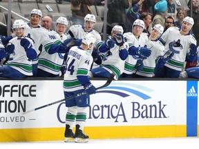 Canucks defenceman Kyle Burroughs (44) is congratulated by teammates after scoring a goal against the San Jose Sharks during the first period at SAP Center at San Jose.