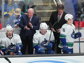 Vancouver Canucks head coach Bruce Boudreau (center) claps at the end of the third period against the San Jose Sharks at SAP Center at San Jose.