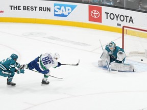 Vancouver Canucks left winger Andrei Kuzmenko (96) scores against San Jose Sharks goaltender Kaapo Kahkonen (36) and defenceman Matt Benning (5) during overtime at SAP Center at San Jose.