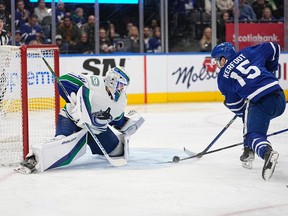 Vancouver Canucks goaltender Spencer Martin, 30, faces Toronto Maple Leafs forward Alexander Carfoot, 15, in the first period at Scotiabank Arena on November 12, 2022. make a save.