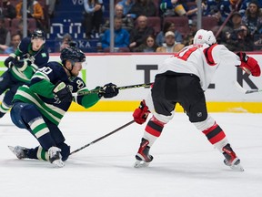 Vancouver Canucks forward Elias Pettersson (40) shoots past New Jersey Devils forward Dawson Mercer (91) in the first period at Rogers Arena on Tuesday night.