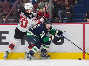 New Jersey Devils forward Jesper Boqvist (70) collides with Vancouver Canucks forward Conor Garland (8) in the first period at Rogers Arena on Tuesday night.