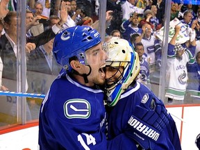 Alex Burrows celebrates with goalie Roberto Luongo after winning the Western Conference trophy after the Canucks beat the Jose Sharks in overtime in Game 5 of the Stanley Cup playoffs at Rogers Arena.