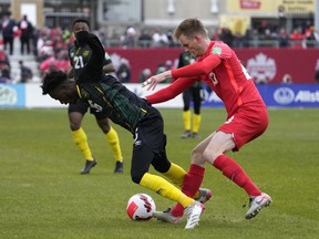 Canada's Scott Kennedy pushes Jamaica's Daniel Green during first half CONCACAF World Cup soccer qualifying action in Toronto on March 27, 2022. Kennedy has suffered a shoulder injury on the eve of the World Cup. SSV Jahn Regensburg, Kennedy's German club, said the 25-year-old from Calgary was injured in last Saturday's 3-0 loss to Rostock.