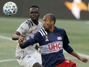 Montreal Impact's Karifa Yao, left, and New England Revolution's Teal Bunbury, right, keep their eyes on the ball during the first half of an MLS soccer match, Wednesday, Sept. 23, 2020, in Foxborough, Mass. The Vancouver Whitecaps picked up Canadian defender Yao in Major League Soccer's re-entry draft on Thursday.